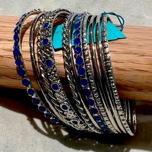 Bangle bracelets in silver tone with blue colored designs. 11 bracelets in set.
